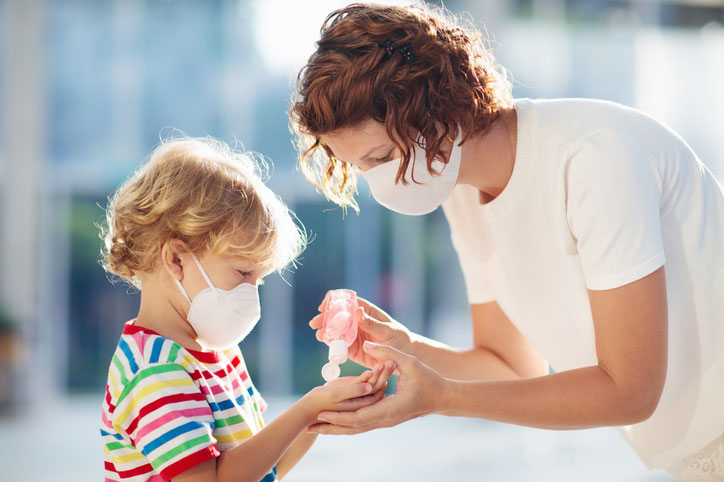 woman helps child with mask